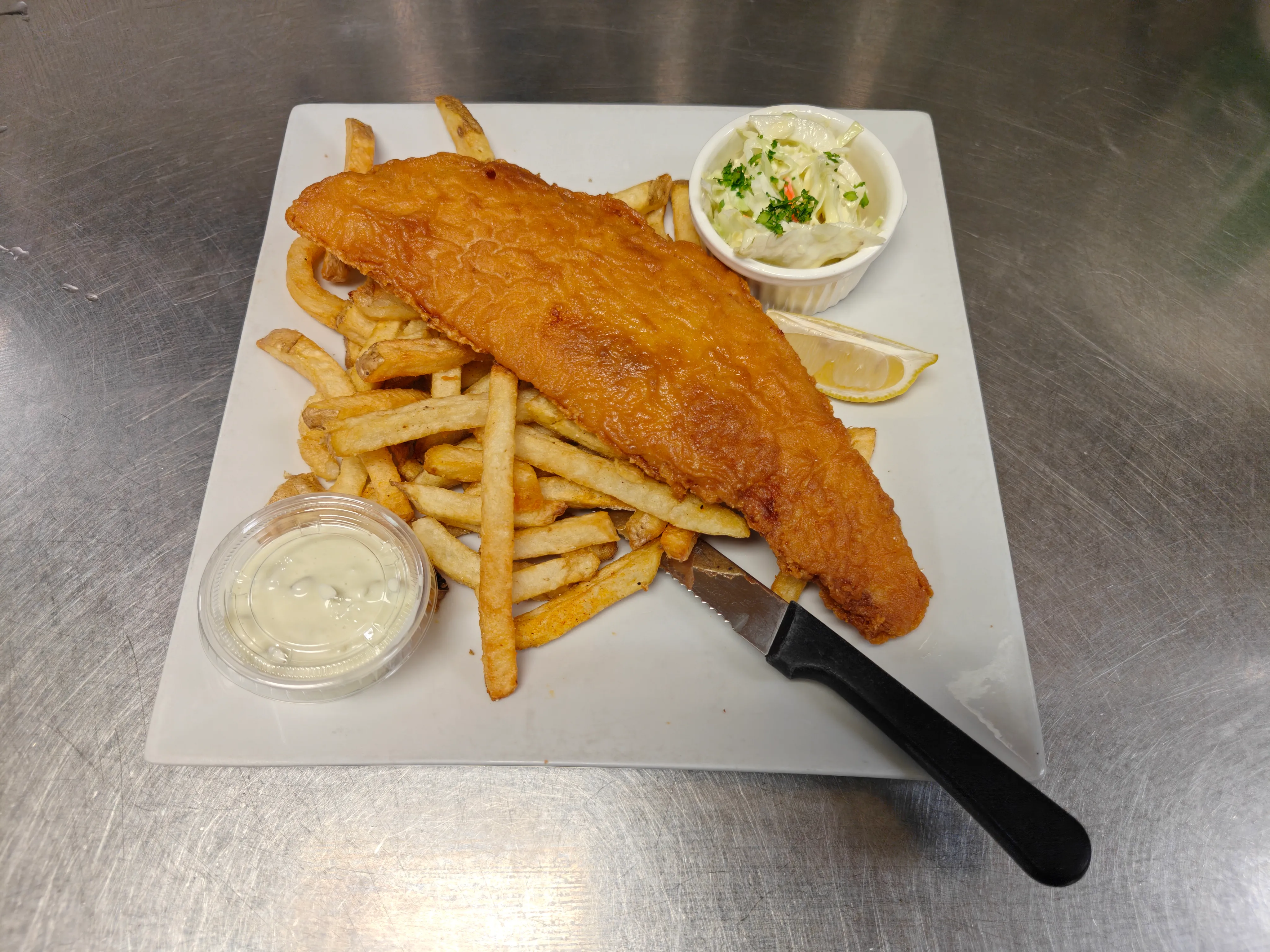 Golden battered haddock with fries, coleslaw and tartar sauce at Cheryl's Country Kitchen in Airdrie, AB